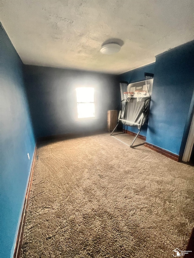 unfurnished bedroom with carpet flooring, a textured ceiling, and baseboards