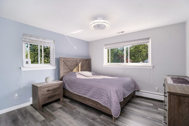 5590 Pembury Ln, West Bloomfield, MI 48322 - bedroom featuring a baseboard heating unit, wood finished floors, and baseboards