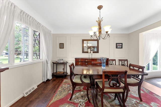 28605 Southpointe Rd, Grosse Ile, MI 48138 - dining room with a chandelier, dark wood-style flooring, a decorative wall, and baseboards