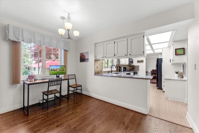 28605 Southpointe Rd, Grosse Ile, MI 48138 - kitchen featuring freestanding refrigerator, a chandelier, wood finished floors, white cabinets, and baseboards