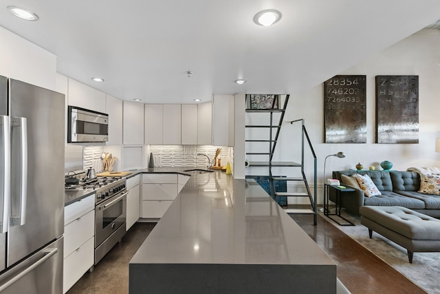 3434 Russell St Unit 28-205, Detroit, MI 48207 - kitchen with stainless steel appliances, open floor plan, white cabinetry, modern cabinets, and a sink