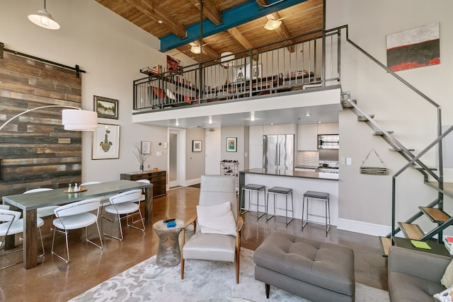 3434 Russell St Unit 28-205, Detroit, MI 48207 - living room featuring wooden ceiling, a towering ceiling, finished concrete floors, a barn door, and beam ceiling