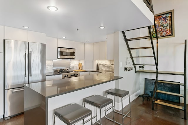 3434 Russell St Unit 28-205, Detroit, MI 48207 - kitchen featuring appliances with stainless steel finishes, dark countertops, decorative backsplash, finished concrete flooring, and baseboards