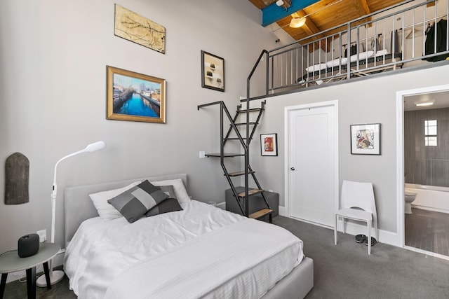 3434 Russell St Unit 28-205, Detroit, MI 48207 - bedroom featuring carpet, wooden ceiling, beam ceiling, baseboards, and connected bathroom