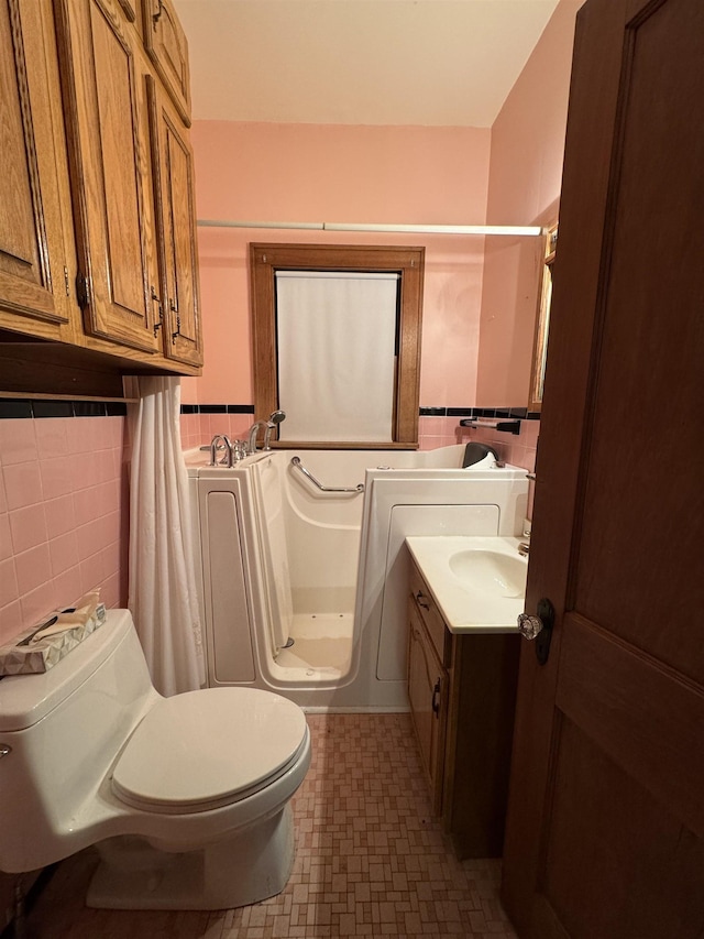 1627 S M-52 Hwy, Owosso, MI 48867 - full bathroom featuring tile walls, toilet, vanity, tile patterned floors, and a shower