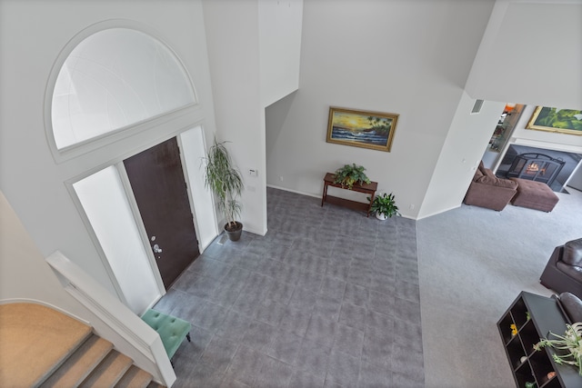 4958 Countryside Dr, West Bloomfield, MI 48323 - entrance foyer featuring a high ceiling, a warm lit fireplace, carpet flooring, and baseboards