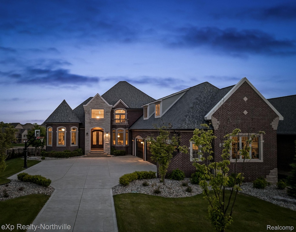 10387 Stoney Point Dr, South Lyon, MI 48178 - french country inspired facade with driveway, a front lawn, brick siding, stone siding, and french doors