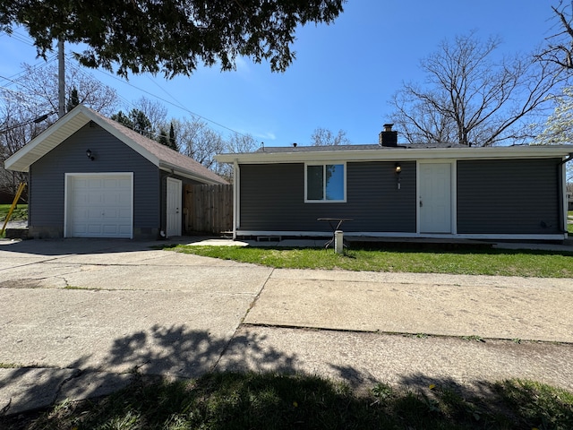 4915 Clarkston Rd, Clarkston, MI 48348 - view of front of house featuring an outbuilding, a detached garage, a chimney, concrete driveway, and fence