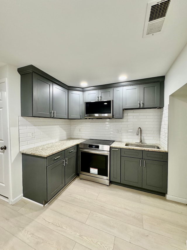 4915 Clarkston Rd, Clarkston, MI 48348 - kitchen featuring appliances with stainless steel finishes, a sink, tasteful backsplash, and light stone countertops
