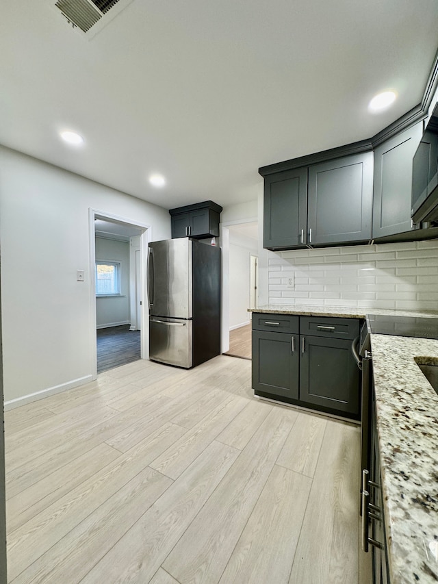 4915 Clarkston Rd, Clarkston, MI 48348 - kitchen featuring freestanding refrigerator, light wood finished floors, decorative backsplash, light stone countertops, and recessed lighting