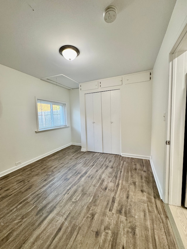 4915 Clarkston Rd, Clarkston, MI 48348 - unfurnished bedroom featuring attic access, wood finished floors, baseboards, and a closet