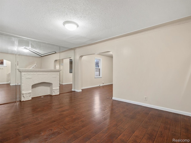 6010 Hartwell St, Dearborn, MI 48126 - unfurnished living room featuring arched walkways, a textured ceiling, hardwood / wood-style floors, and baseboards