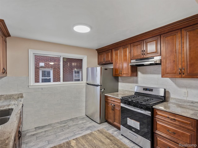 6010 Hartwell St, Dearborn, MI 48126 - kitchen featuring appliances with stainless steel finishes, under cabinet range hood, brown cabinets, and tile walls