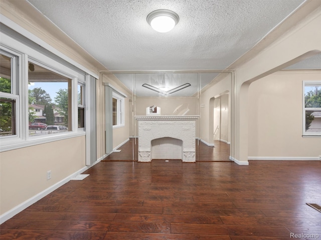 6010 Hartwell St, Dearborn, MI 48126 - unfurnished living room featuring a textured ceiling, hardwood / wood-style floors, arched walkways, and baseboards