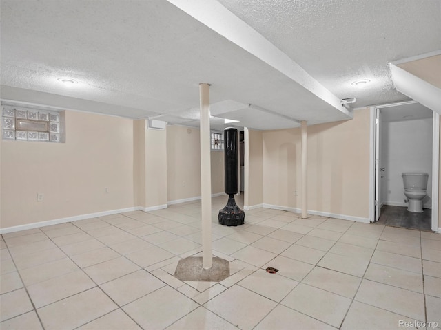6010 Hartwell St, Dearborn, MI 48126 - finished below grade area with a textured ceiling, light tile patterned flooring, and baseboards