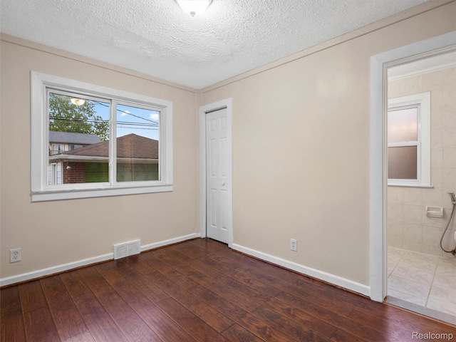6010 Hartwell St, Dearborn, MI 48126 - unfurnished bedroom featuring wood-type flooring, baseboards, a textured ceiling, a closet, and connected bathroom