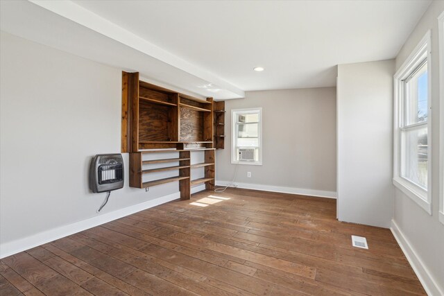 unfurnished living room with heating unit, hardwood / wood-style floors, plenty of natural light, recessed lighting, and baseboards