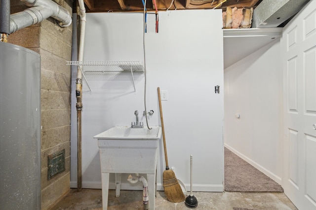 bathroom with concrete block wall, baseboards, and concrete floors