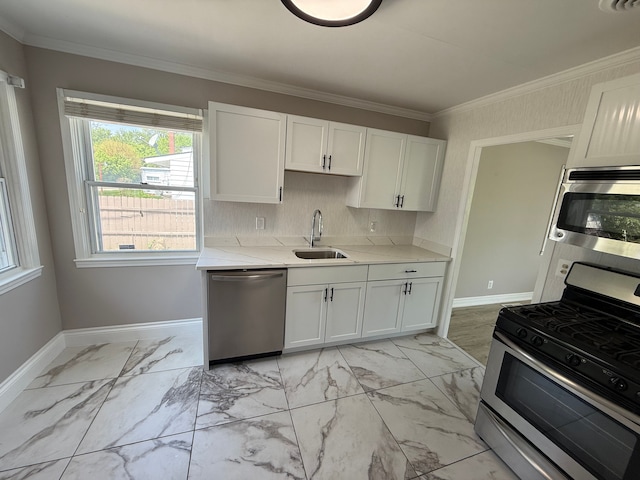 kitchen with appliances with stainless steel finishes, a sink, light marble finish floors, white cabinets, and ornamental molding