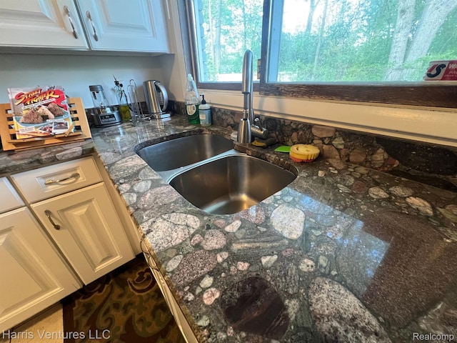 29430 Marimoor Dr, Southfield, MI 48076 - kitchen view of a sink, white cabinetry, and dark stone counters