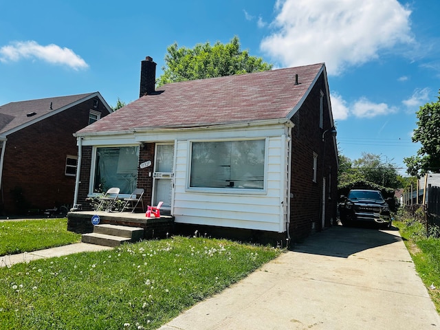 11329 Minock St, Detroit, MI 48228 - bungalow-style home featuring a chimney, a front yard, driveway, and brick siding