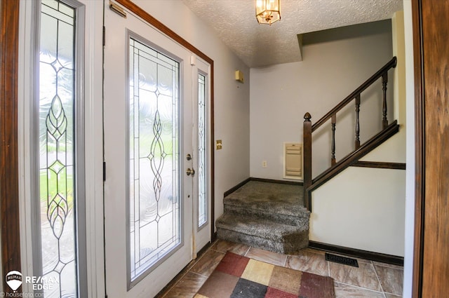 500 Granger Rd, Ortonville, MI 48462 - foyer entrance featuring stairs, a textured ceiling, and baseboards