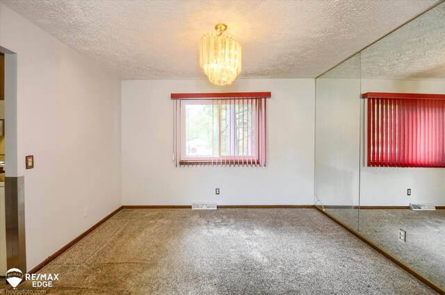 500 Granger Rd, Ortonville, MI 48462 - carpeted spare room with a textured ceiling, a chandelier, and baseboards