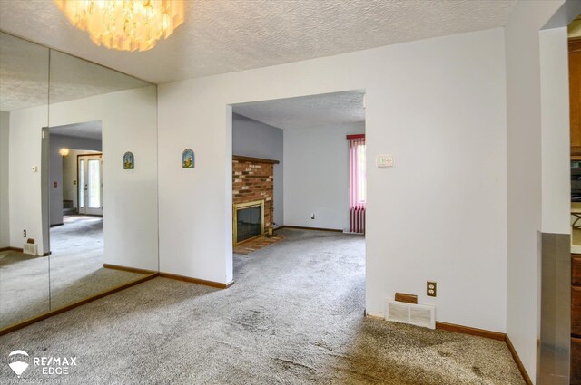 500 Granger Rd, Ortonville, MI 48462 - carpeted spare room with plenty of natural light, a fireplace, a textured ceiling, baseboards, and a chandelier