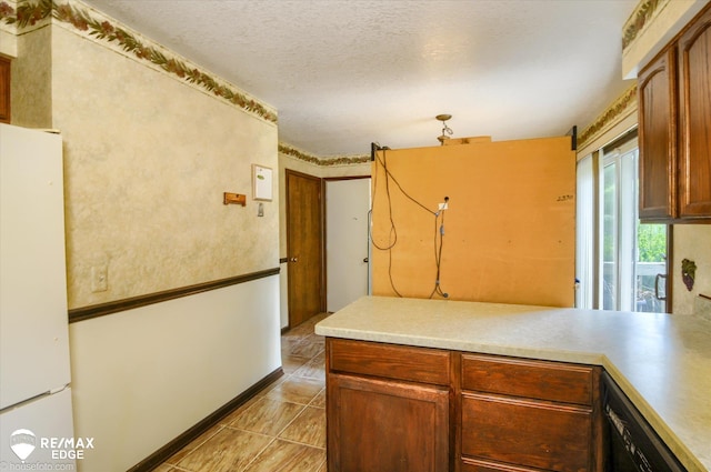 500 Granger Rd, Ortonville, MI 48462 - kitchen with freestanding refrigerator, black dishwasher, a peninsula, light countertops, and a textured ceiling