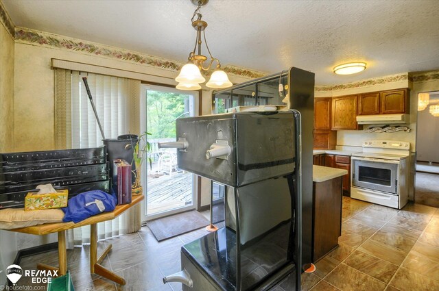 500 Granger Rd, Ortonville, MI 48462 - kitchen with white range with electric cooktop, under cabinet range hood, light countertops, brown cabinetry, and decorative light fixtures