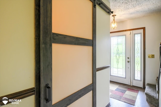 500 Granger Rd, Ortonville, MI 48462 - entrance foyer with healthy amount of natural light, a barn door, and a textured ceiling