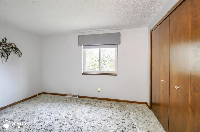 500 Granger Rd, Ortonville, MI 48462 - unfurnished bedroom with carpet floors, a closet, baseboards, and a textured ceiling
