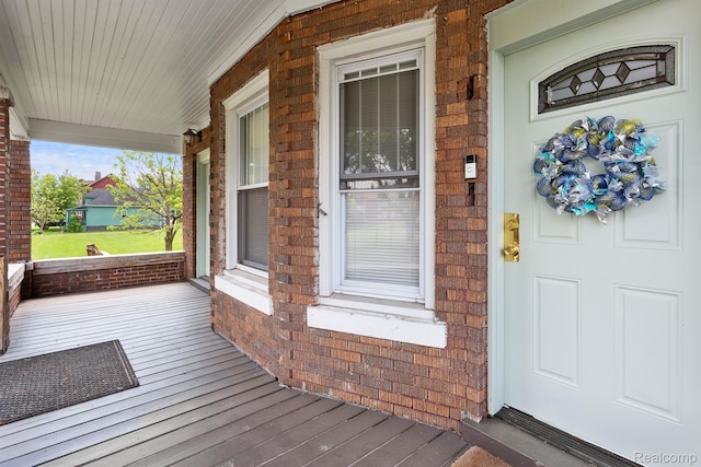 7501 Dunedin St, Detroit, MI 48206 - doorway to property with covered porch and brick siding