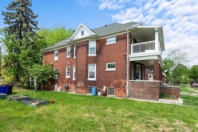 7501 Dunedin St, Detroit, MI 48206 - view of side of home featuring a balcony, brick siding, a yard, a shingled roof, and a vegetable garden