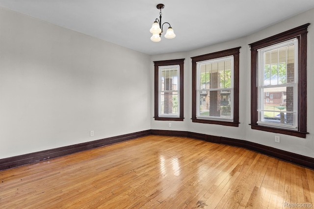 7501 Dunedin St, Detroit, MI 48206 - empty room featuring a chandelier, light wood finished floors, and baseboards
