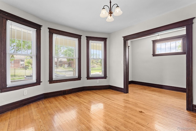 7501 Dunedin St, Detroit, MI 48206 - unfurnished room featuring a chandelier, baseboards, and light wood-type flooring