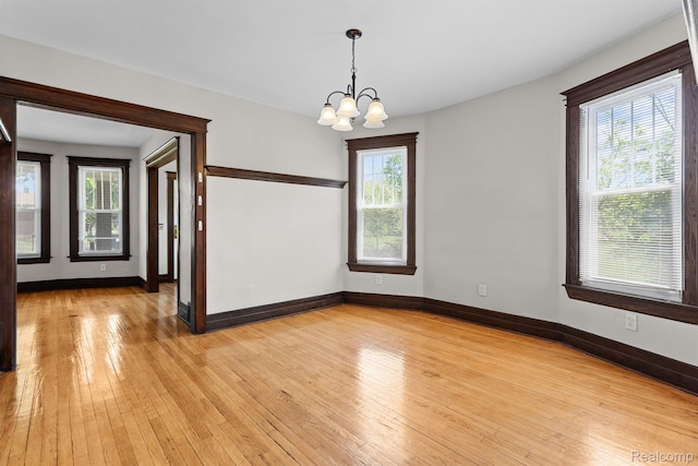 7501 Dunedin St, Detroit, MI 48206 - empty room featuring a chandelier, light wood-type flooring, and plenty of natural light