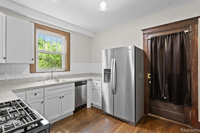 7501 Dunedin St, Detroit, MI 48206 - kitchen with appliances with stainless steel finishes, a sink, tasteful backsplash, dark wood finished floors, and white cabinetry