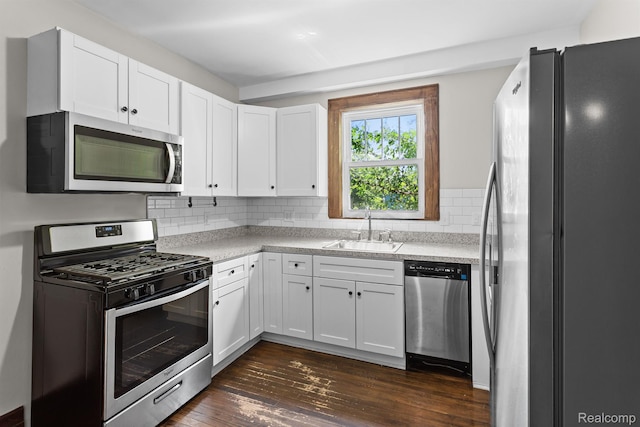 7501 Dunedin St, Detroit, MI 48206 - kitchen featuring appliances with stainless steel finishes, a sink, light countertops, white cabinetry, and tasteful backsplash