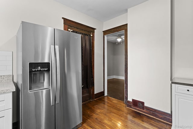7501 Dunedin St, Detroit, MI 48206 - kitchen featuring stainless steel fridge with ice dispenser, dark wood-style floors, a ceiling fan, baseboards, and white cabinetry