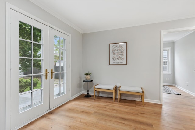 sitting room with french doors, crown molding, light wood-style floors, and baseboards