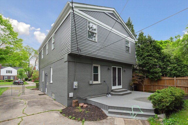 back of property featuring fence and brick siding