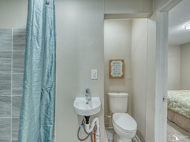19106 Sylvia Ave, Romulus, MI 48174 - bathroom with a textured ceiling, toilet, and a shower with curtain