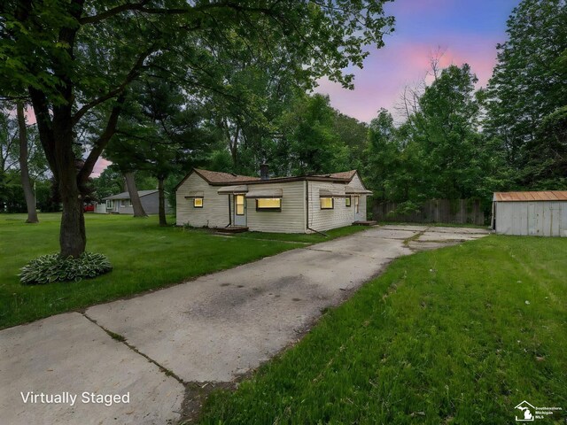 19106 Sylvia Ave, Romulus, MI 48174 - view of front of house featuring a front lawn, an outbuilding, a storage shed, and driveway