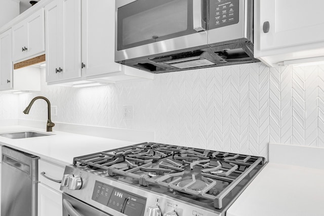 436 E Milwaukee St Unit 8, Detroit, MI 48202 - kitchen featuring stainless steel appliances, a sink, light countertops, backsplash, and white cabinets