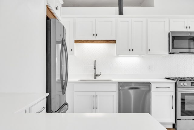436 E Milwaukee St Unit 8, Detroit, MI 48202 - kitchen with stainless steel appliances, a sink, tasteful backsplash, and white cabinetry