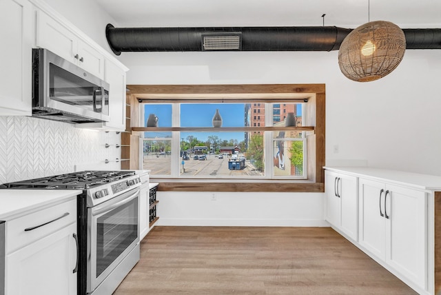 436 E Milwaukee St Unit 8, Detroit, MI 48202 - kitchen with stainless steel appliances, tasteful backsplash, light wood-style flooring, white cabinetry, and light countertops