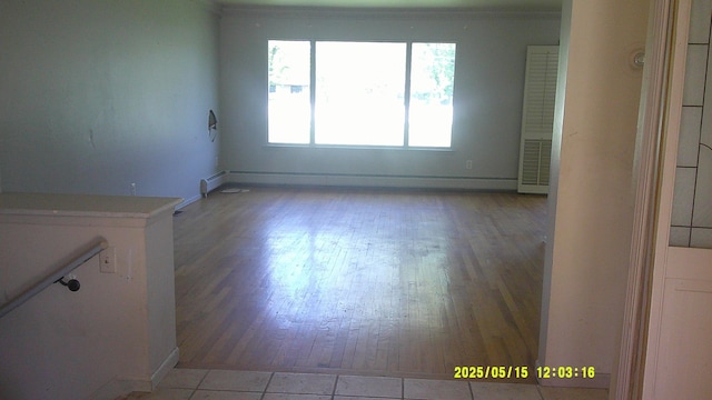 8240 Hampton Rd, Grosse Ile, MI 48138 - unfurnished room featuring a baseboard radiator, light wood-style floors, and baseboards