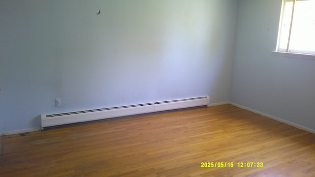 8240 Hampton Rd, Grosse Ile, MI 48138 - empty room featuring baseboard heating, wood finished floors, and baseboards