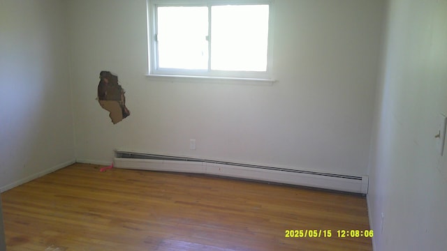 8240 Hampton Rd, Grosse Ile, MI 48138 - spare room with a baseboard heating unit, wood finished floors, and baseboards